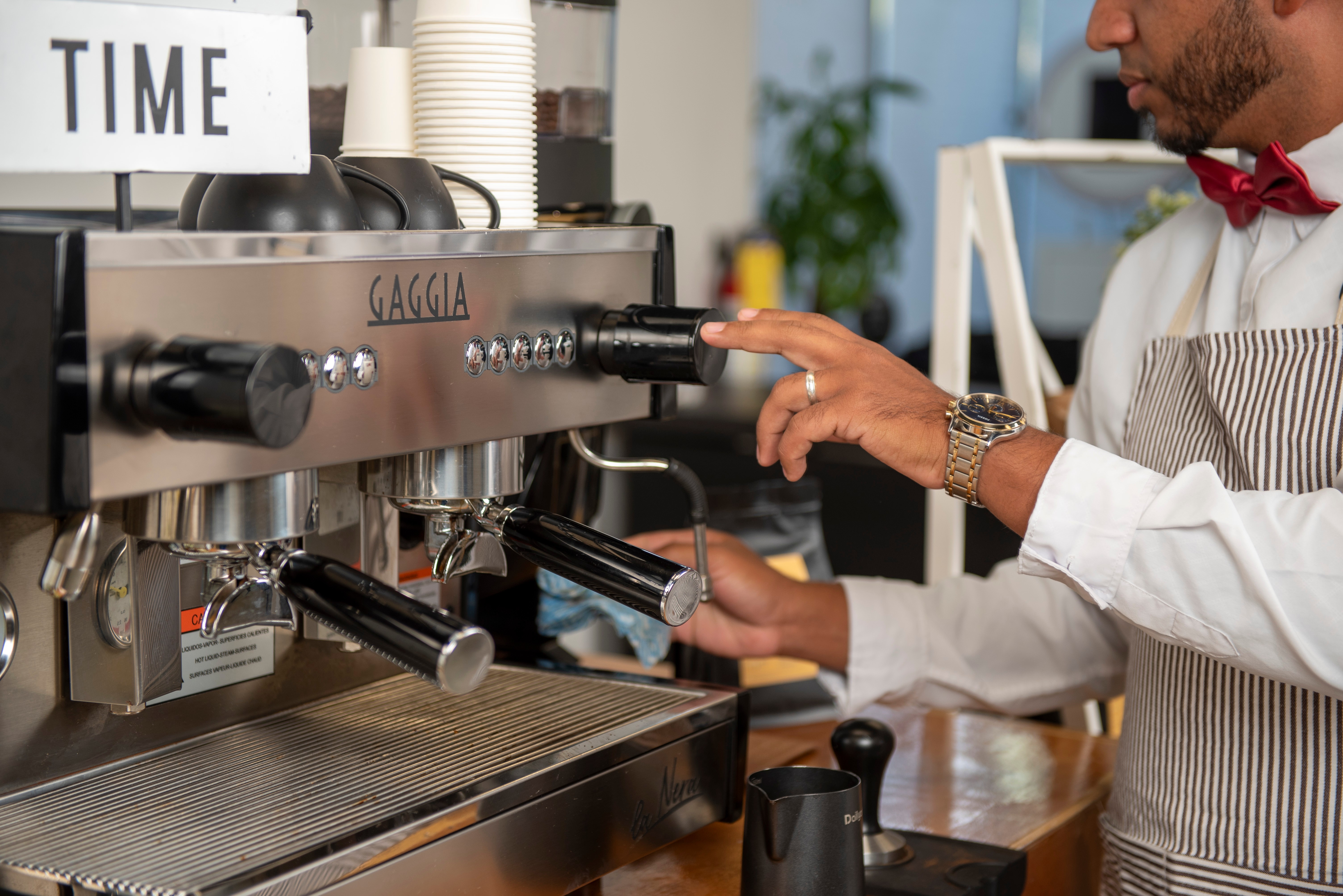 Professional barista operating premium Gaggia espresso machine with precision and expertise