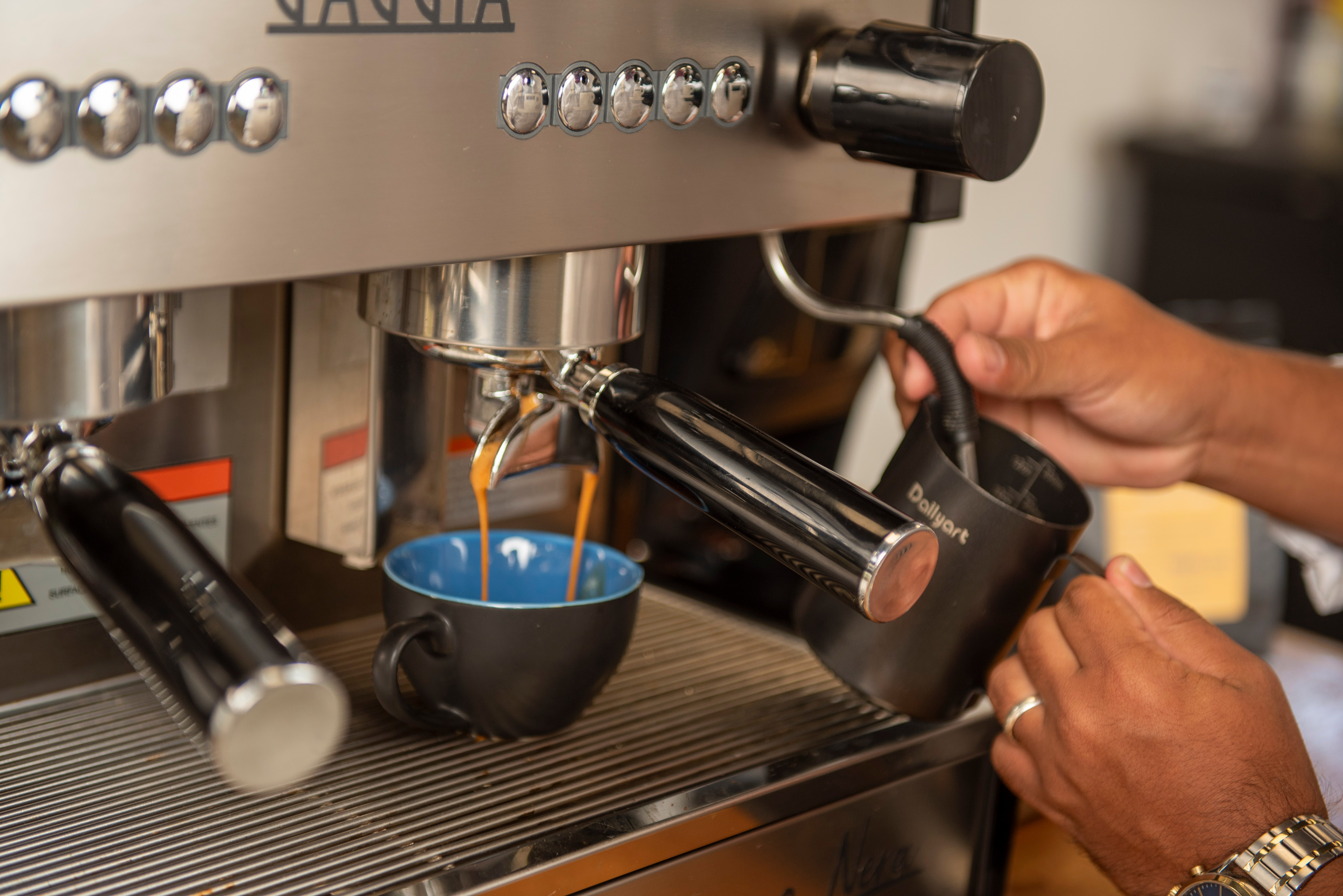 Professional barista operating espresso machine with expertise