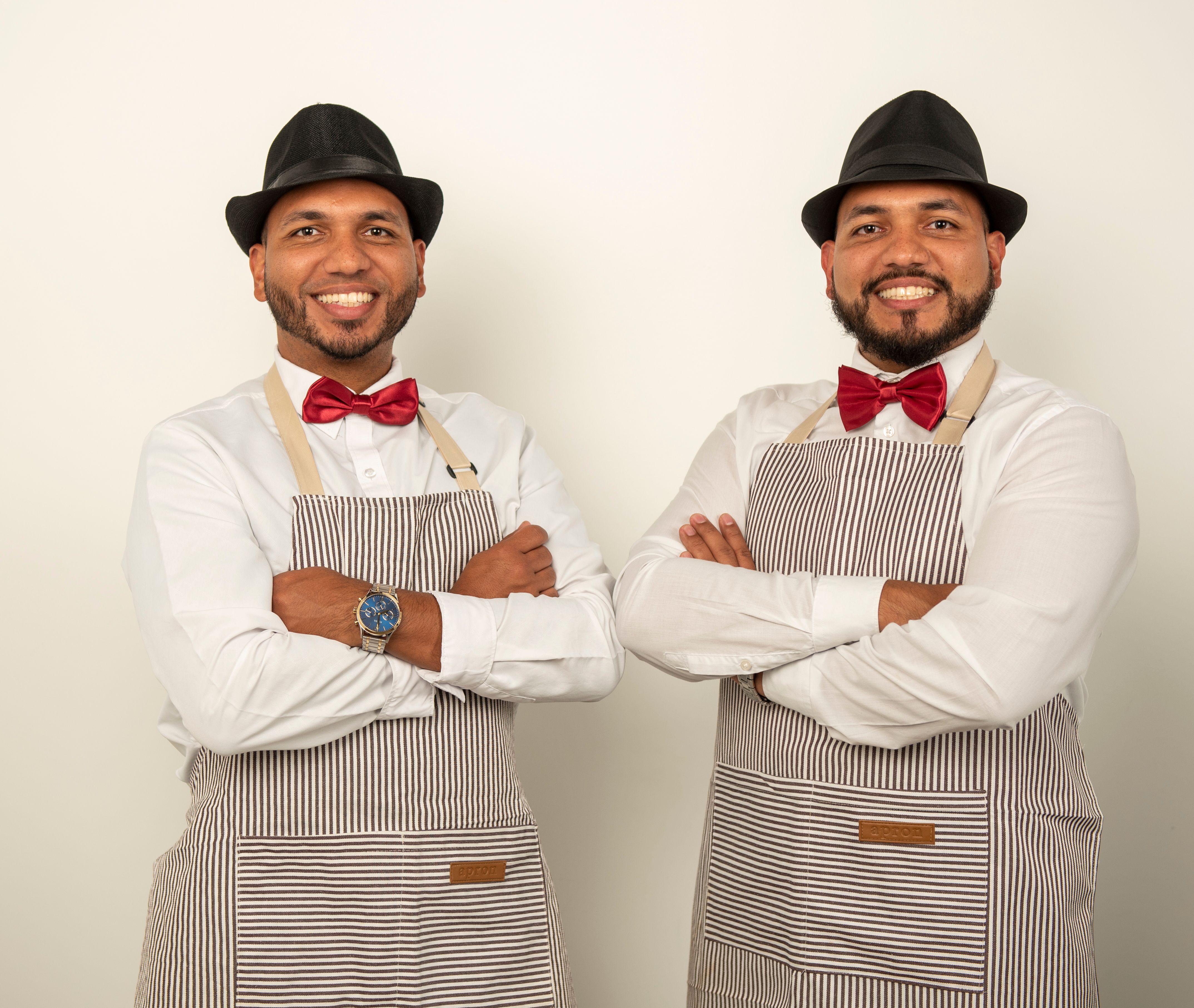 Two professional male baristas in elegant uniforms with confident professional stance