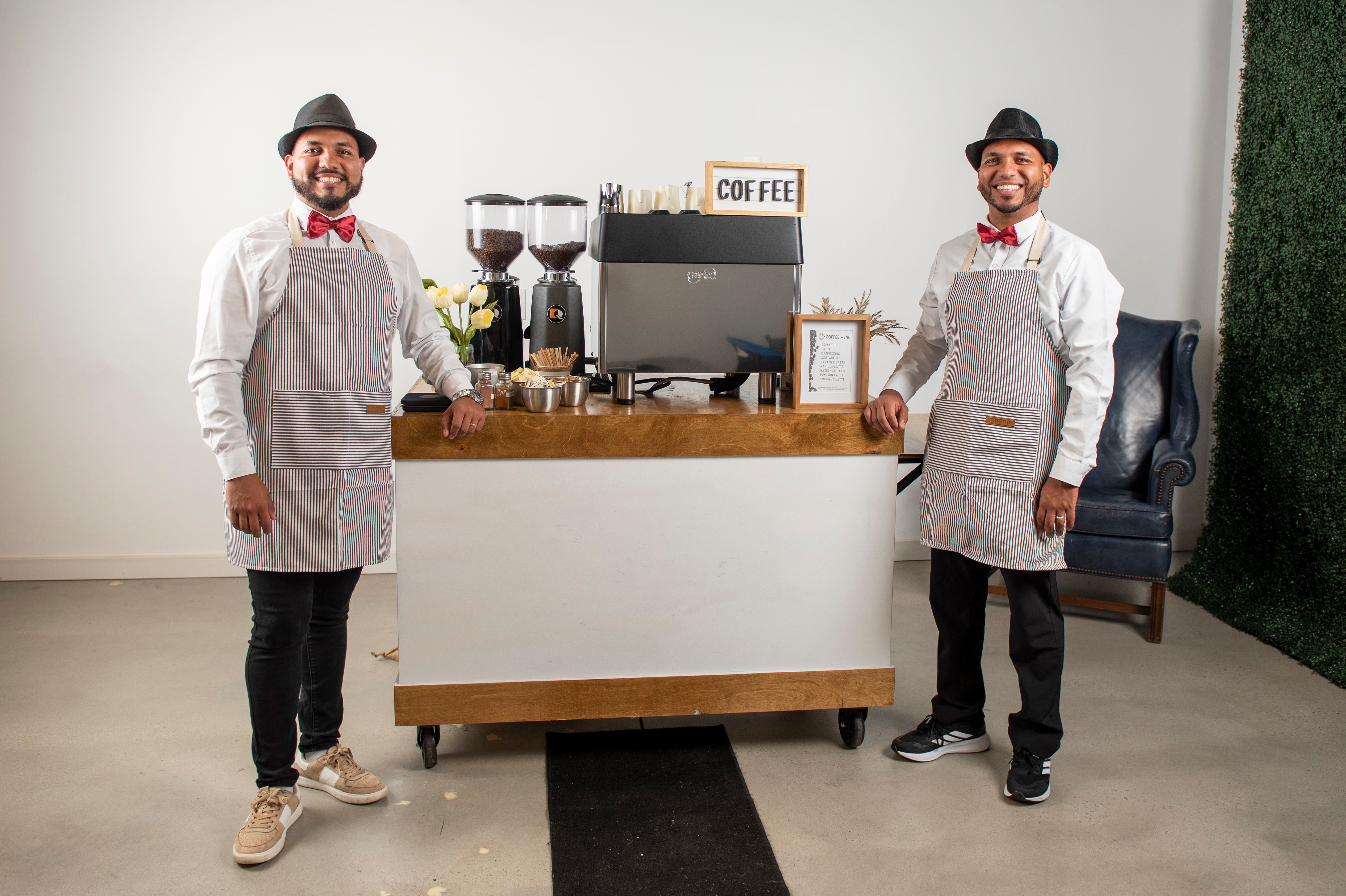 Two professional baristas with premium mobile coffee station in corporate setting